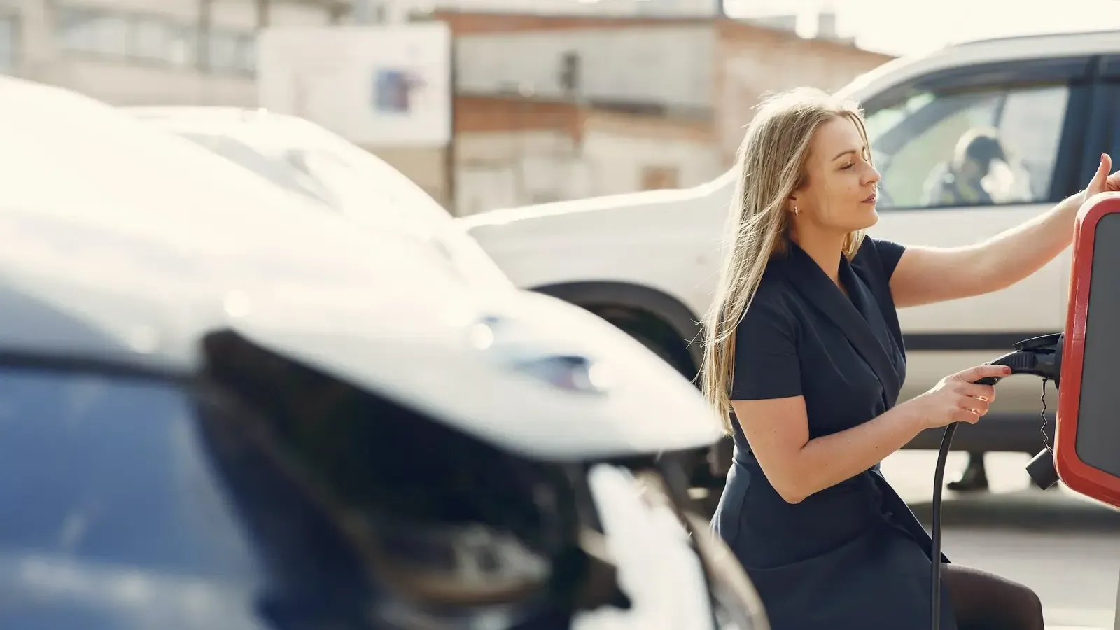 Woman putting EV Charger back into station