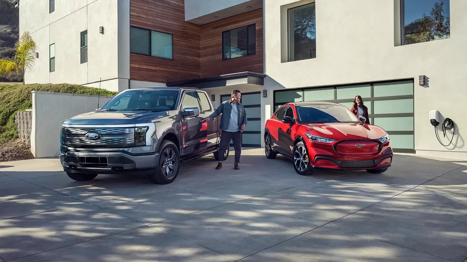 Green Ford F-150 Lightning and red Mustang Mach-E on display side-by-side