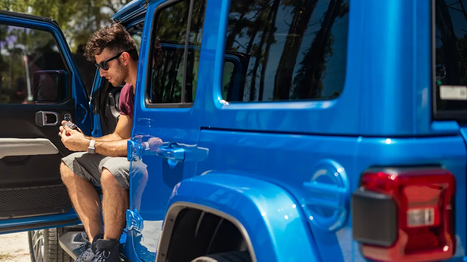 Man Sitting outside electric blue vehicle
