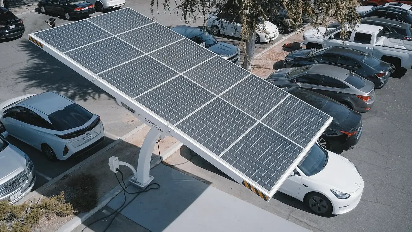 cars charging by solar panel in parking lot