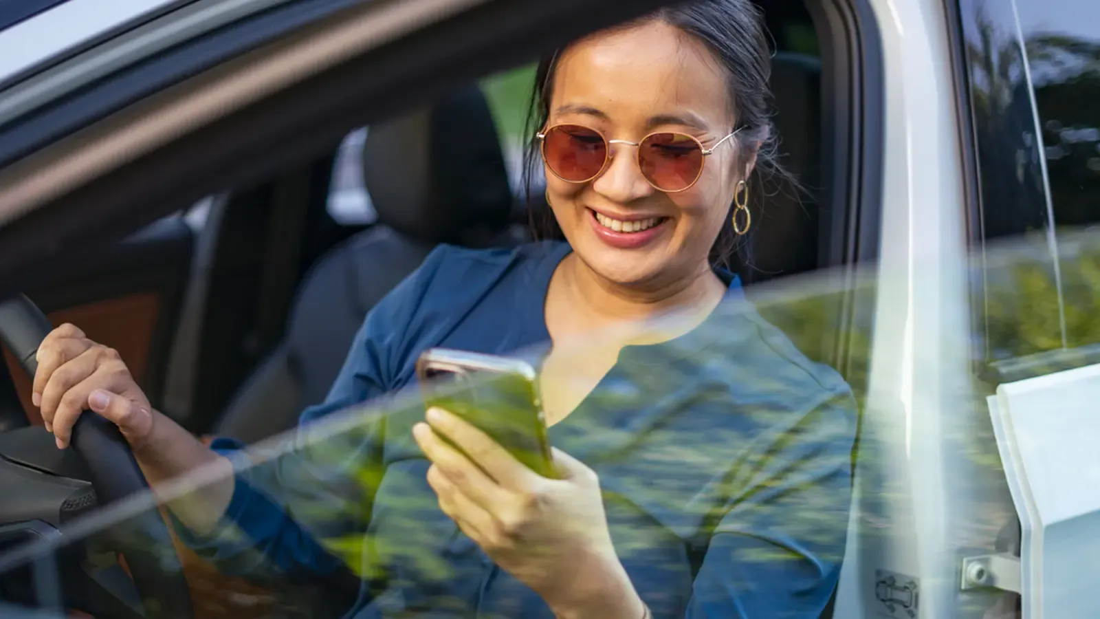 woman using her phone as she exits the car