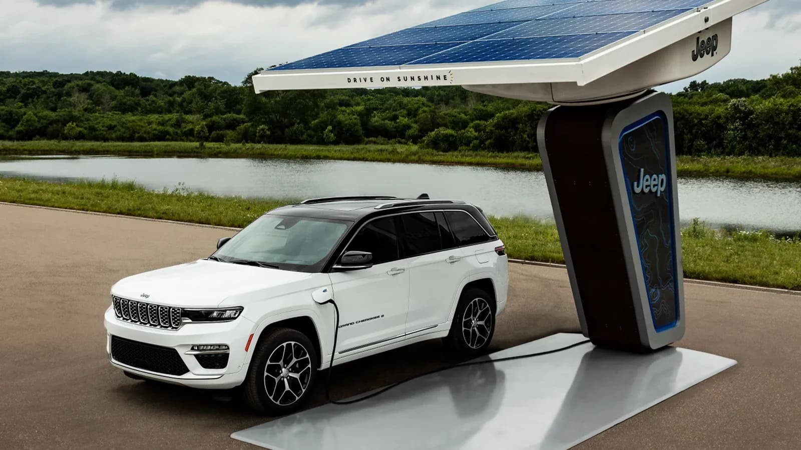 Jeep Grand Cherokee 4xe charging at a station with solar energy