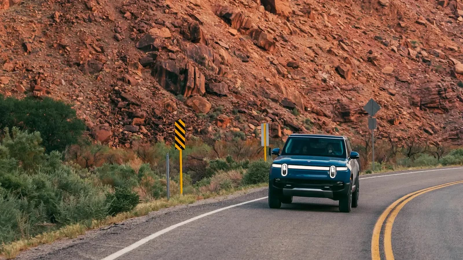 Rivian R1S SUV driving on the road in Desert