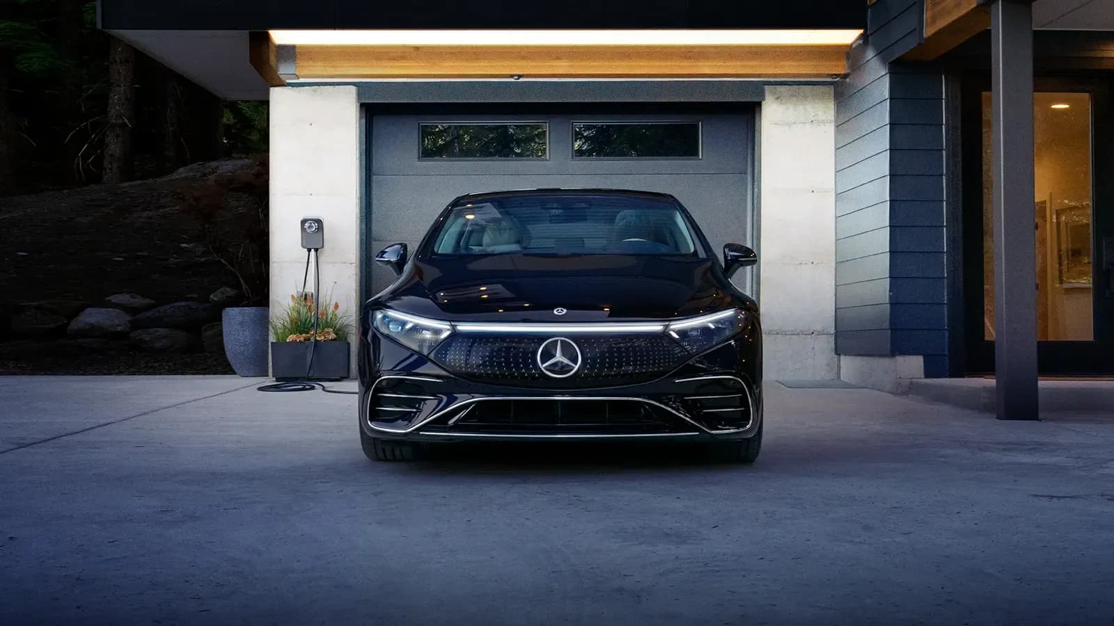 New Mercedes-Benz EQS parked outside a garage at night