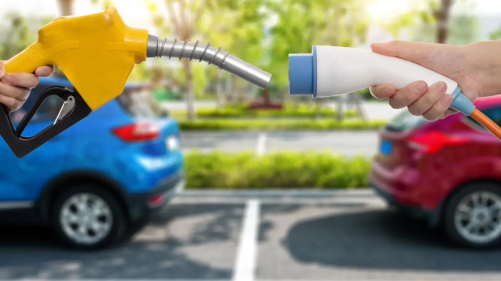 two hands holding an ev charger vs a person who prefers gas