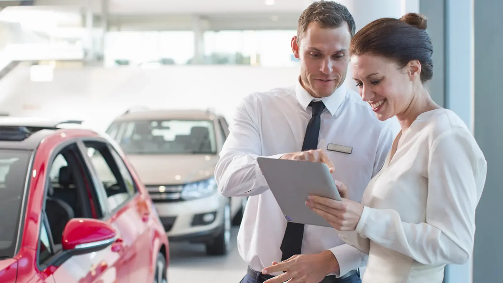 Woman and man at a dealership checking a tablet