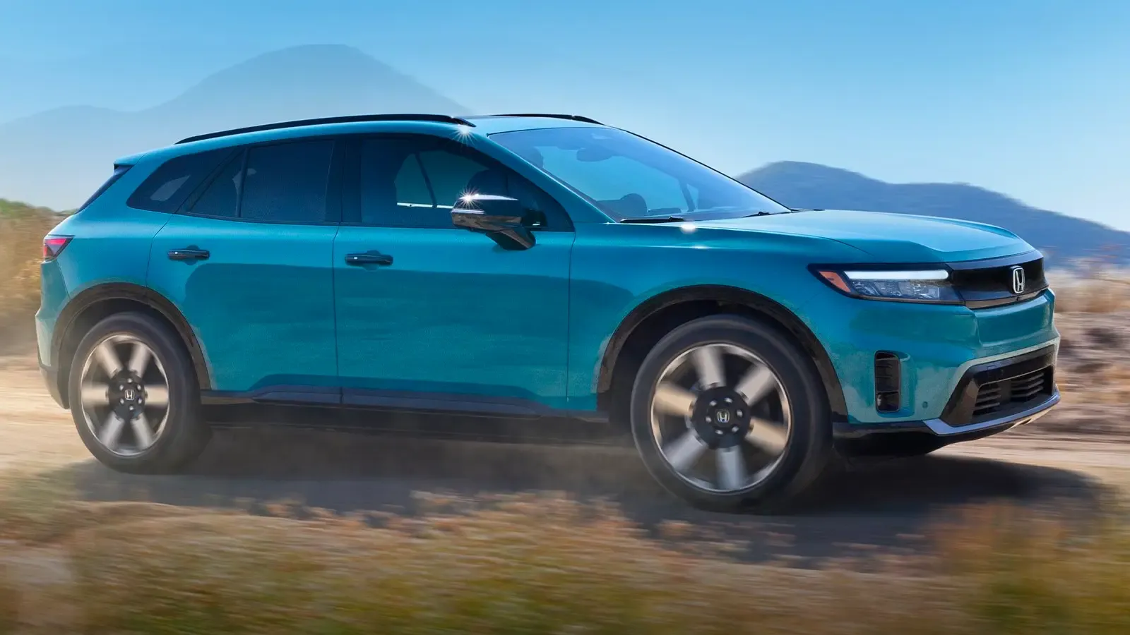 Honda Prologue driving on a road by mountains