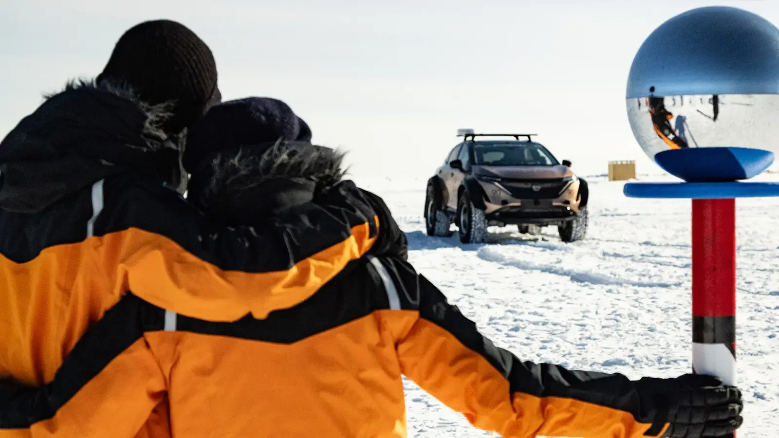 Chris and Julie Ramsey, husband and wife adventurers, facing their Nissan Ariya they used on their pole to pole expedition