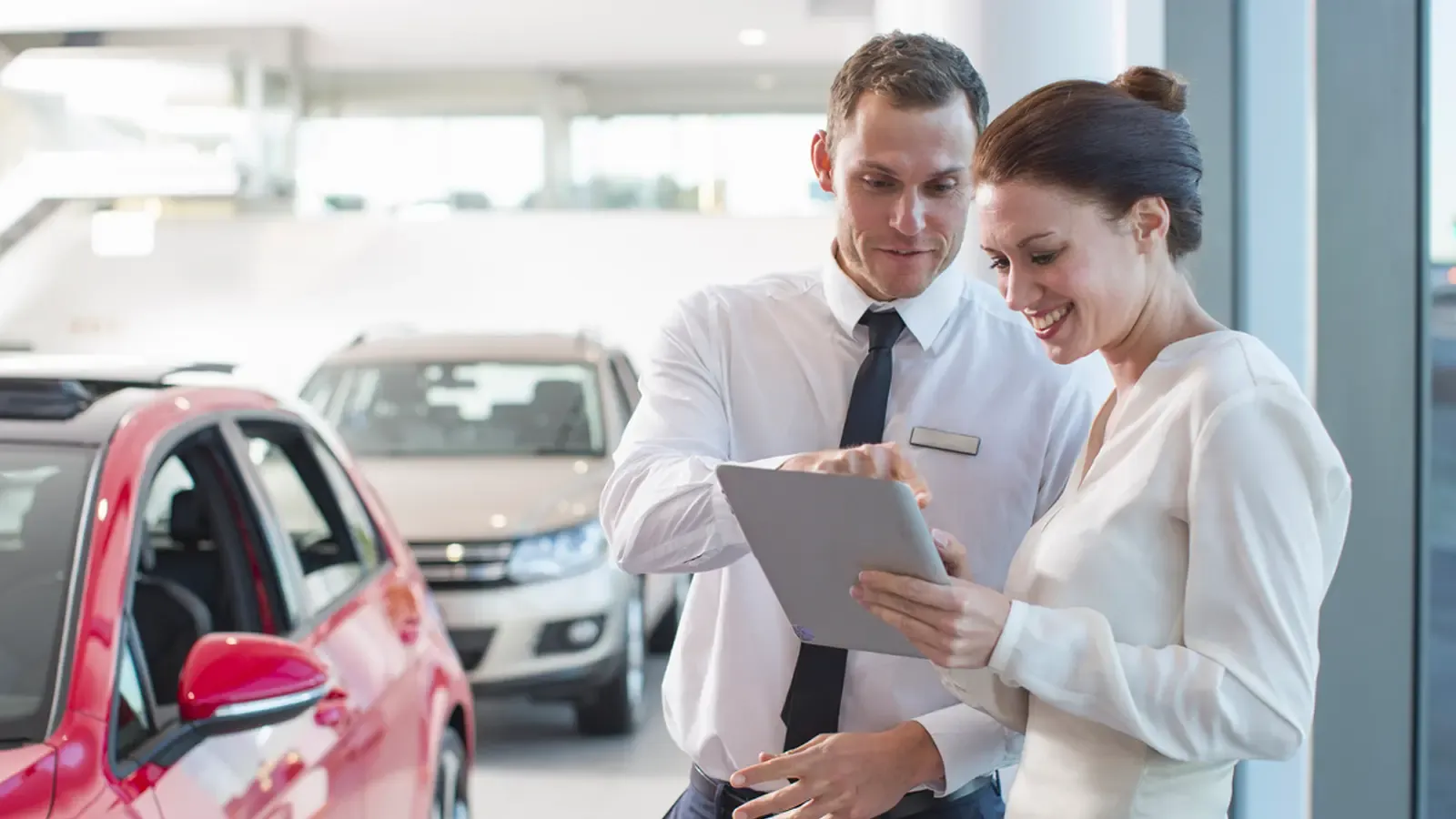 Dealership employee and client looking over information on a tablet device