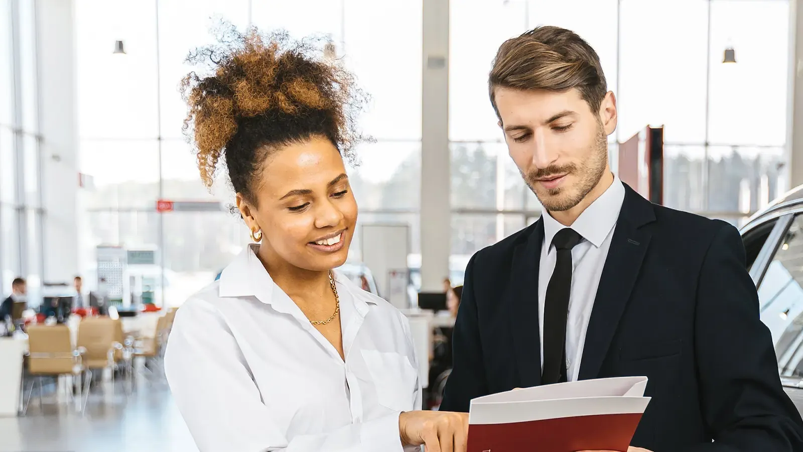 Dealership employee and client looking over paperwork