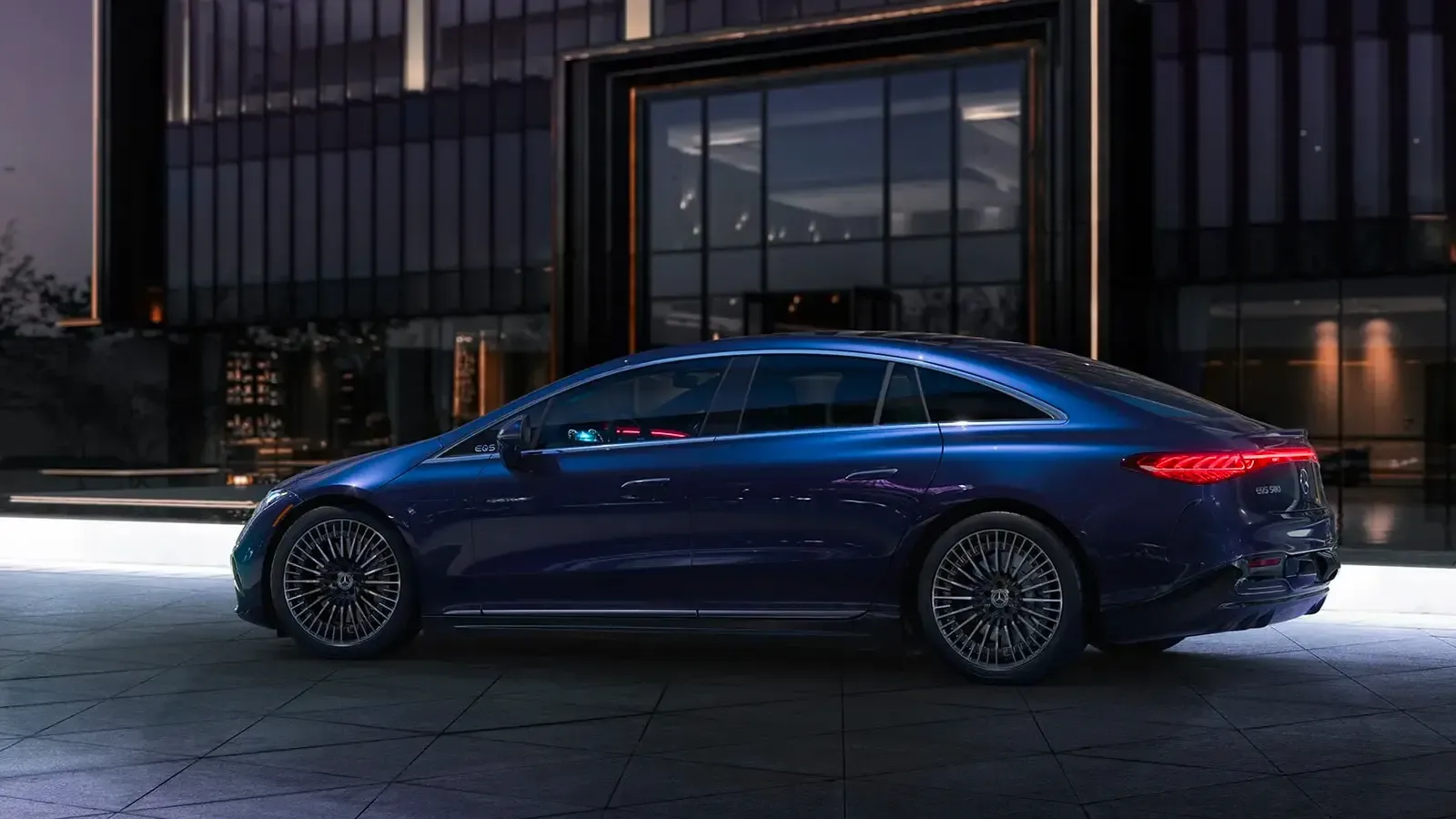 Side exterior view of Mercedes EQS parked by a building