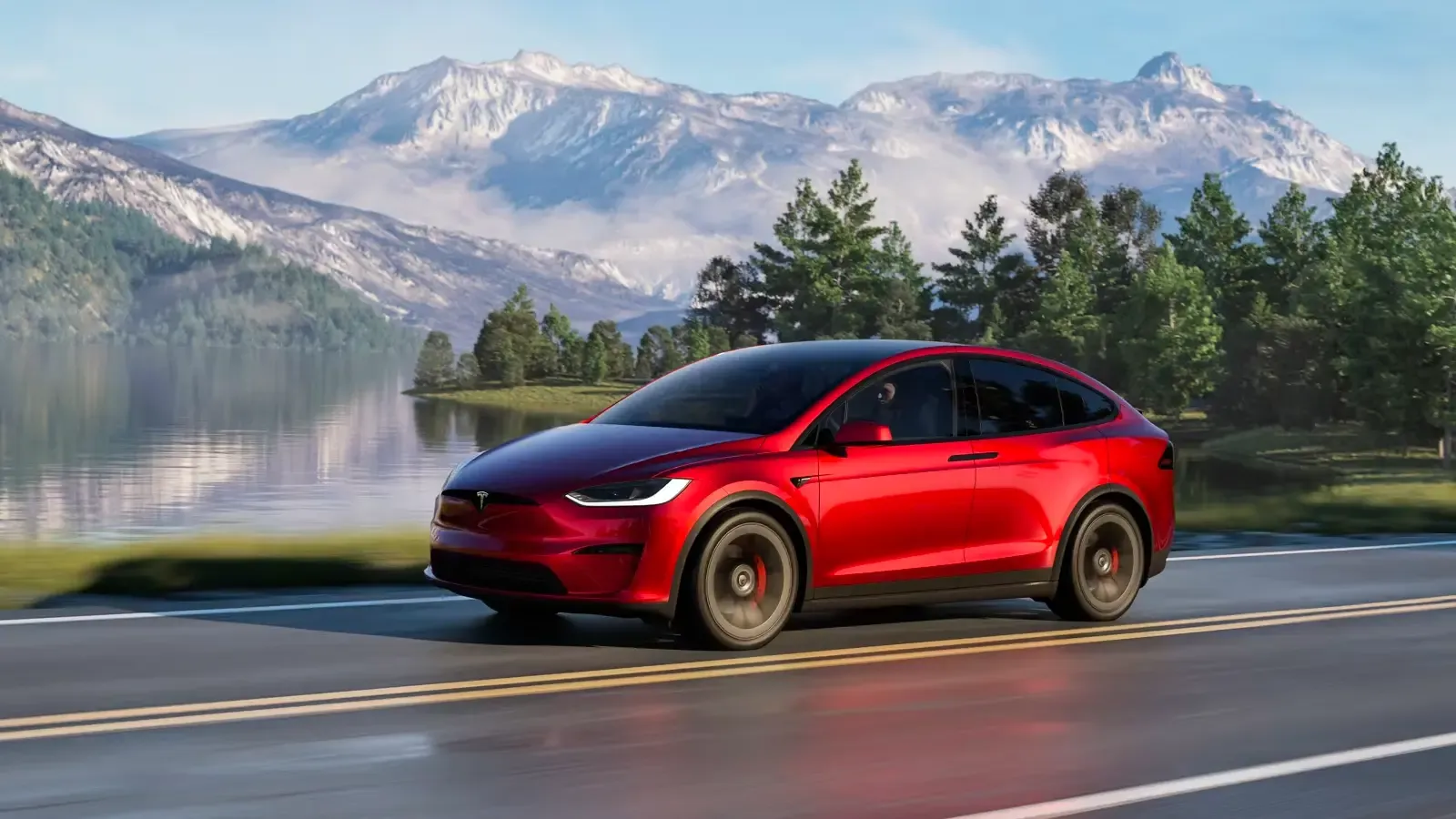 Tesla Model X driving on a road by a mountainous landscape