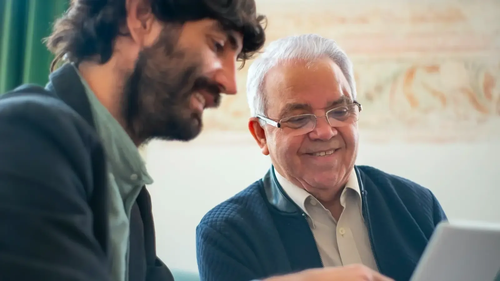 Two men overlooking their tablet