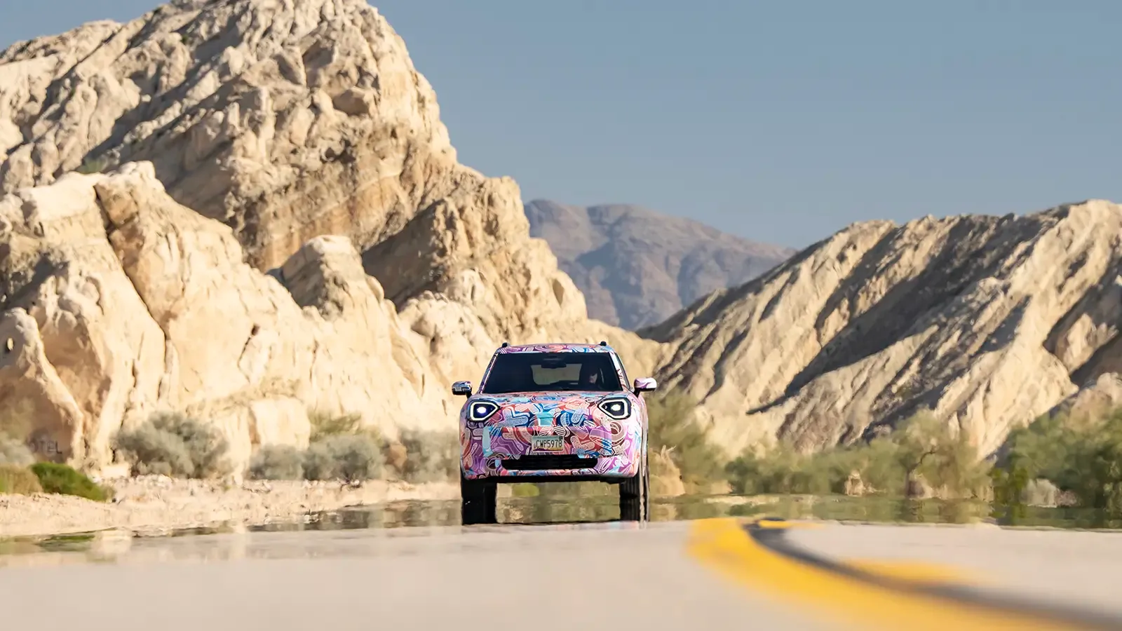 Front exterior view of the Mini Aceman EV driving on a mountainous road