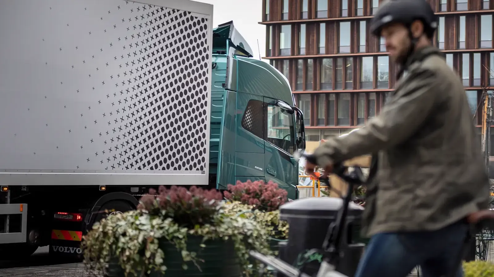 electric truck with man on scooter in frame