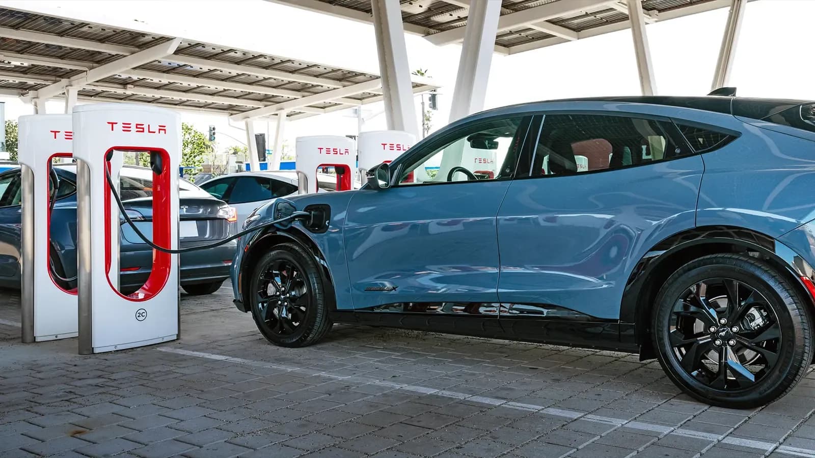 Blue Ford EV using a Tesla Supercharger