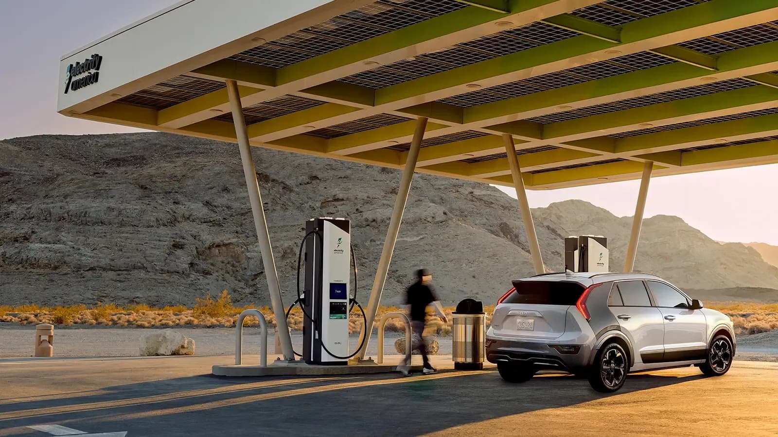 white electric SUV parked charging under a solar-powered EV charging station