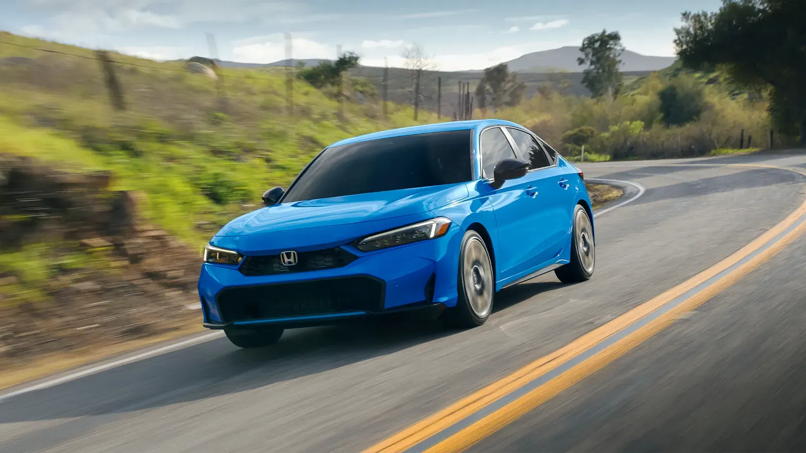 Blue Honda Civic Hybrid driving on the road