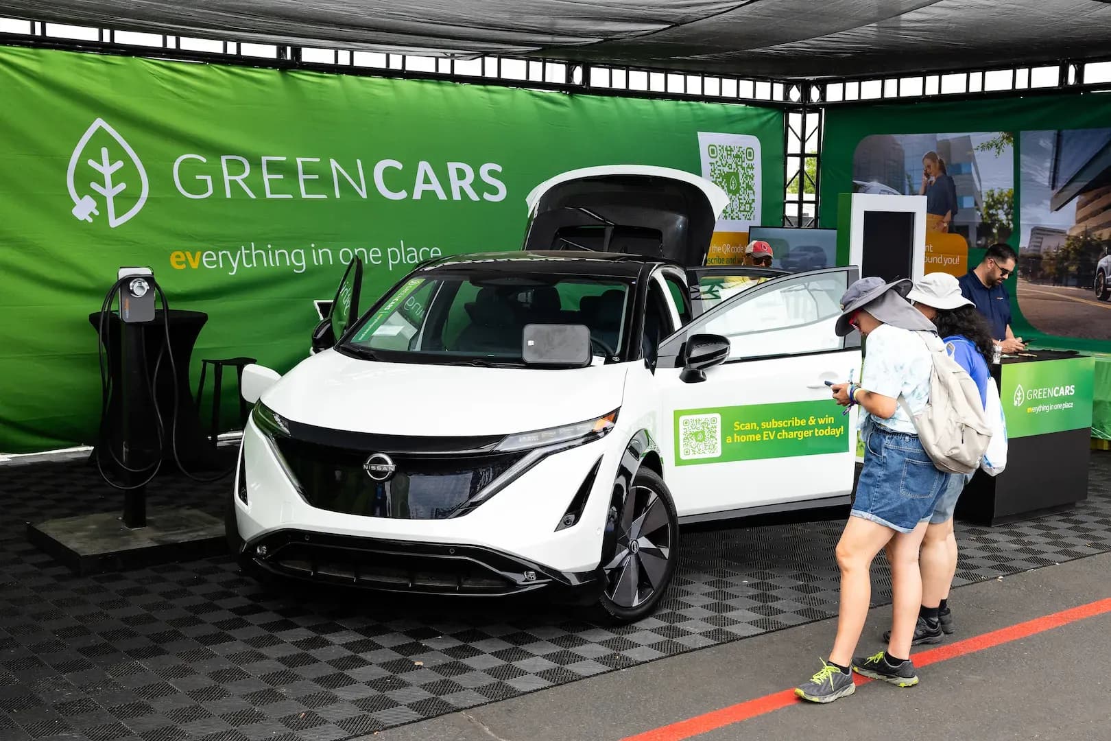 A Nissan Ariya electric vehicle parked at the GreenCars booth