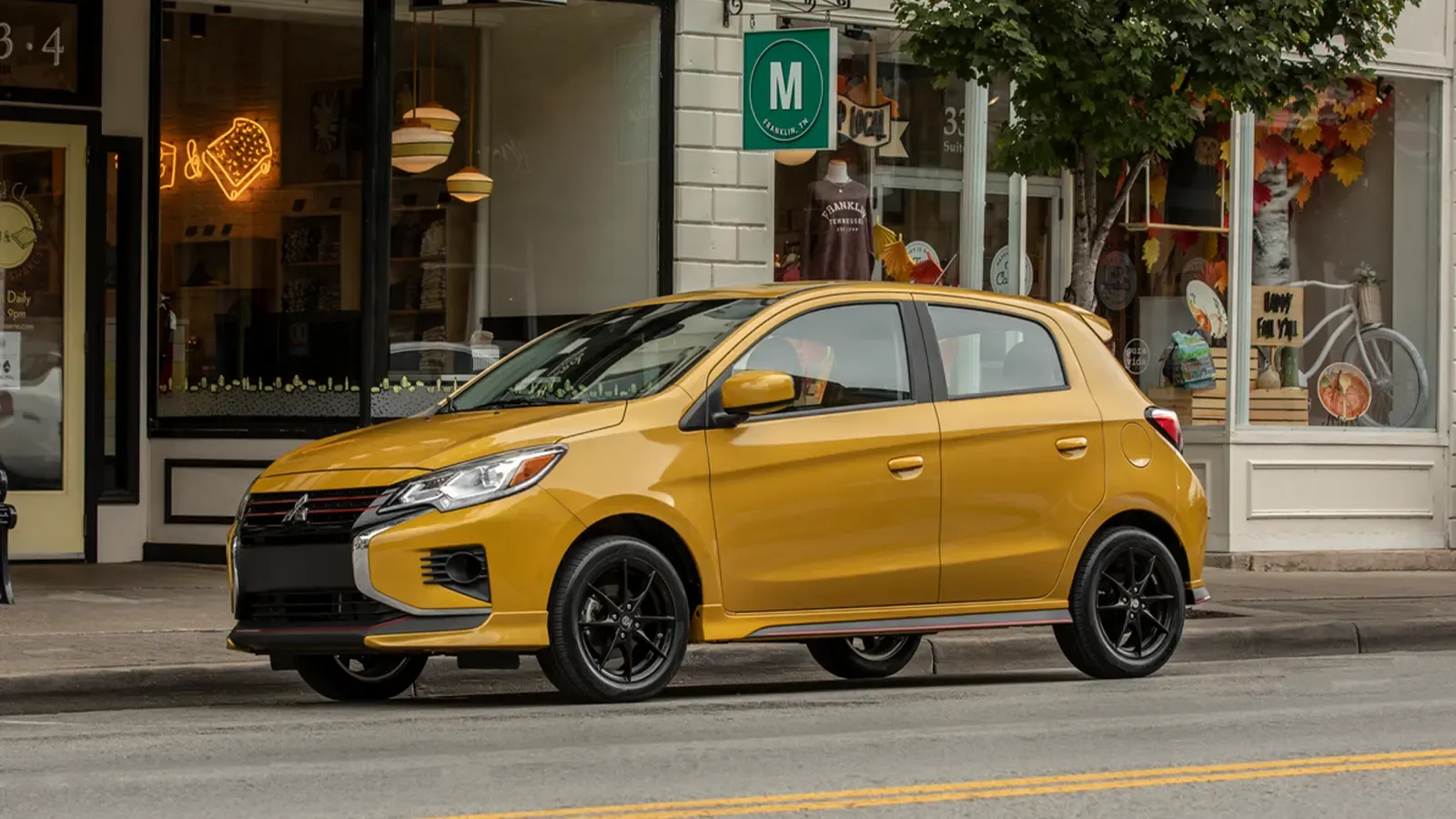 Mitsubishi Mirage arked outside of loal shops