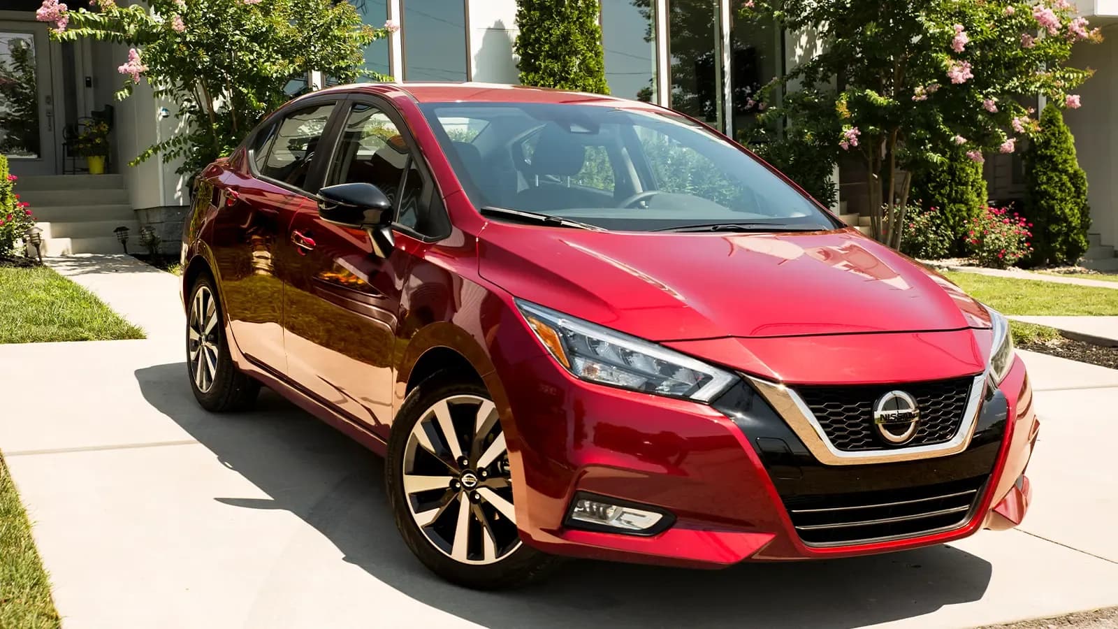 Red Nissan Versa parked in driveway