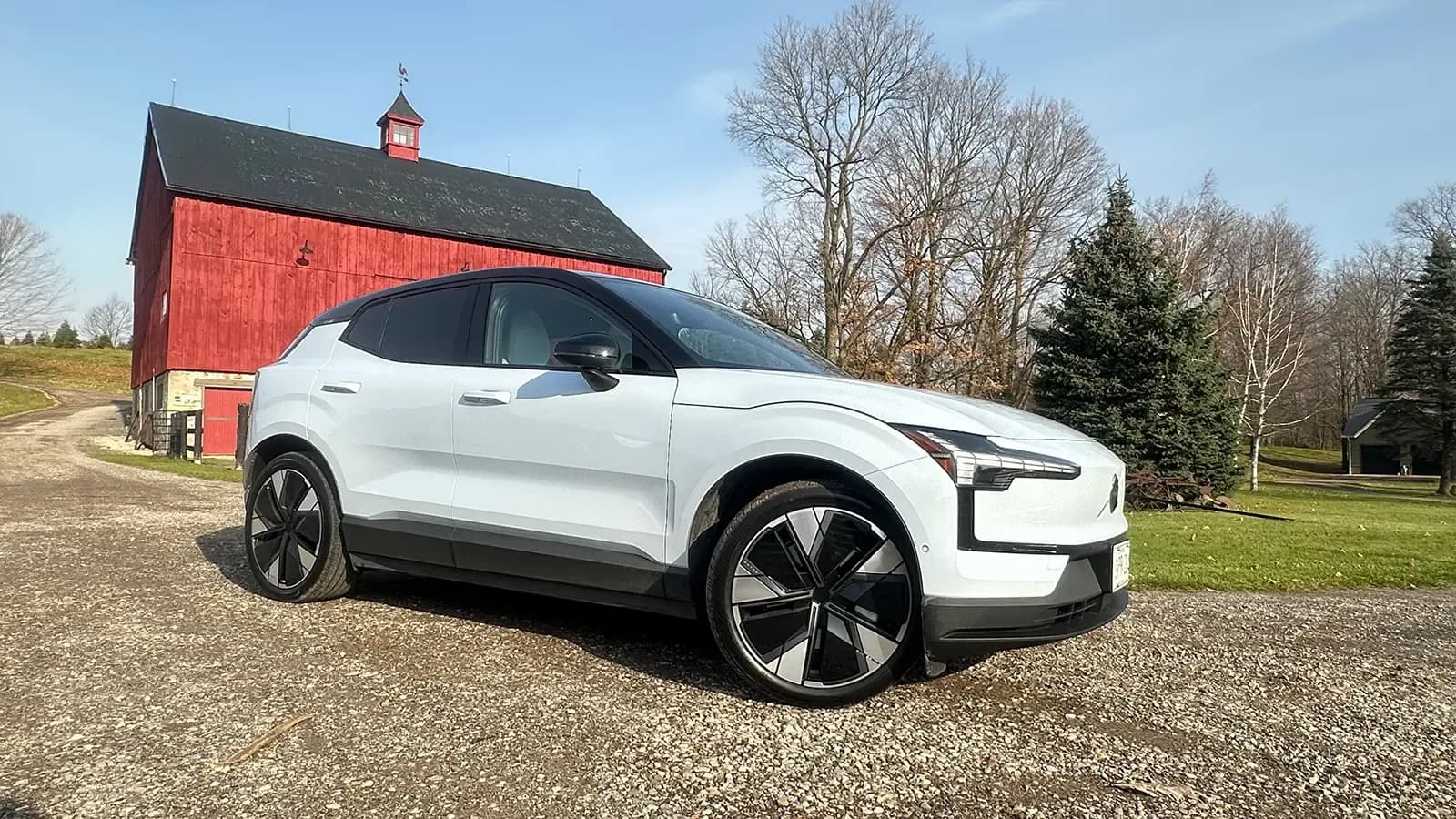 white Volvo EX30 parked in front of a barn