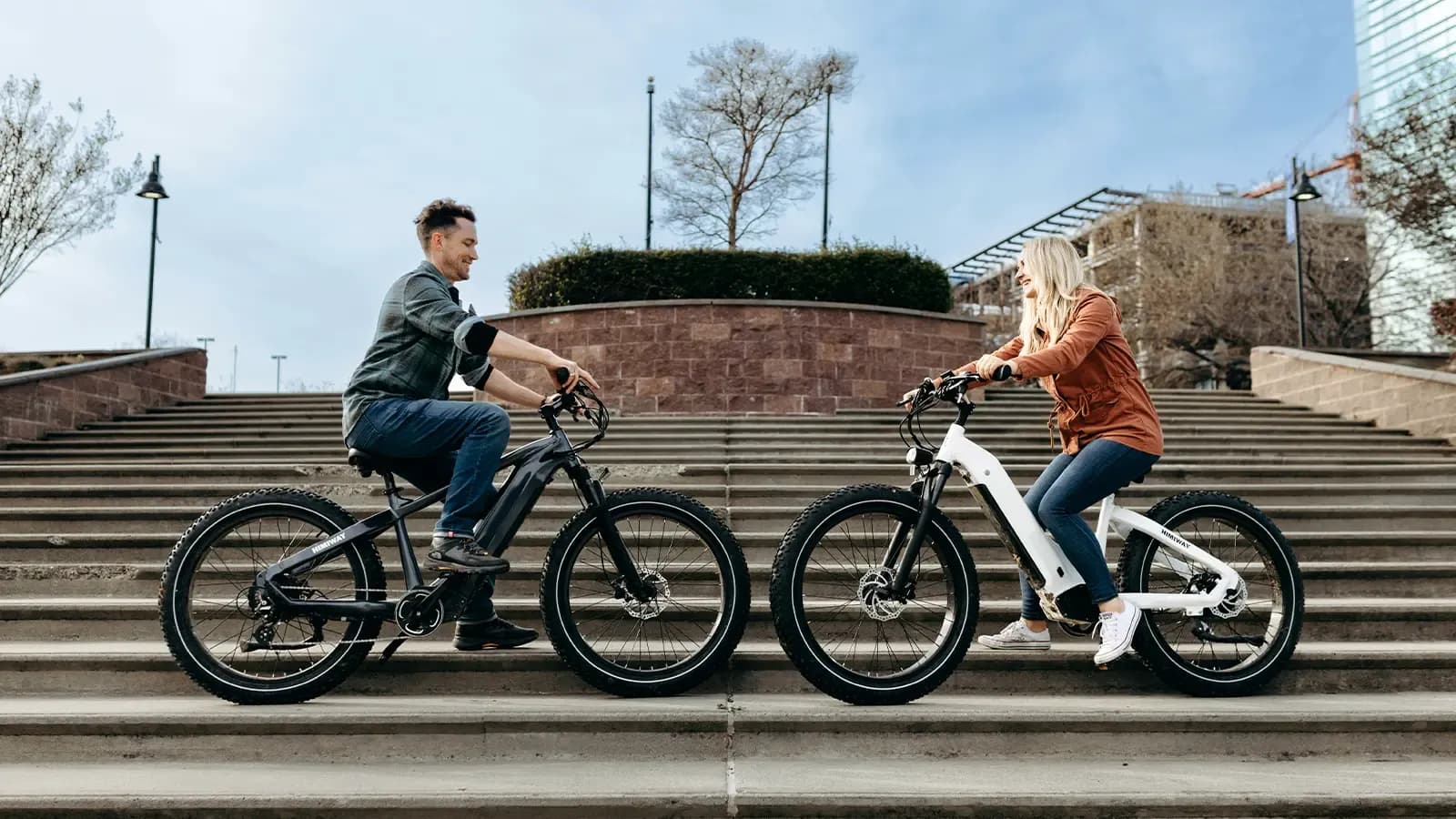 man and woman riding e-bikes