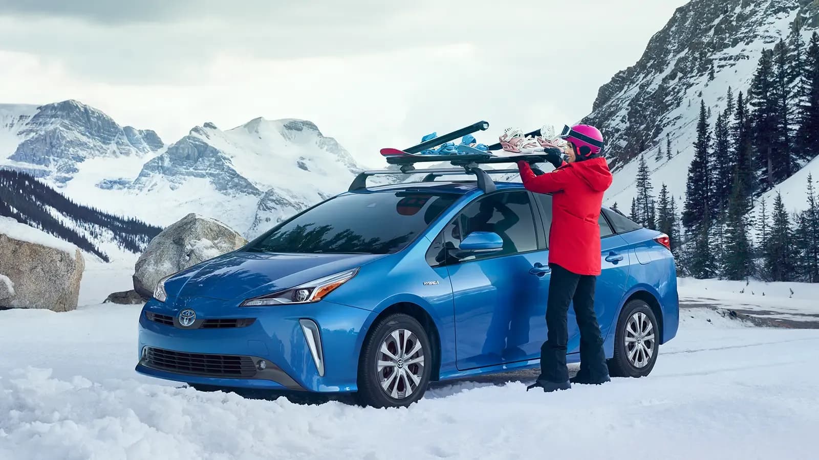 Woman with Toyota Camry Hybrid on top of a mountain