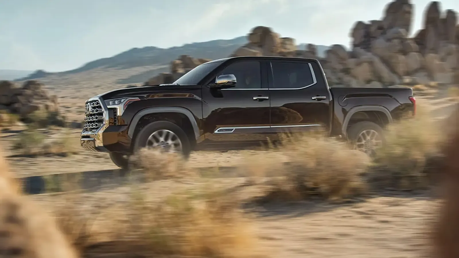 Black Toyota Tundra hybrid driving in the desert