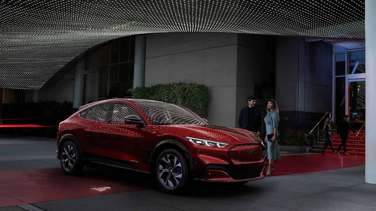 Couple receiving their Ford mustang Mach-E from Valet at a red carpet event