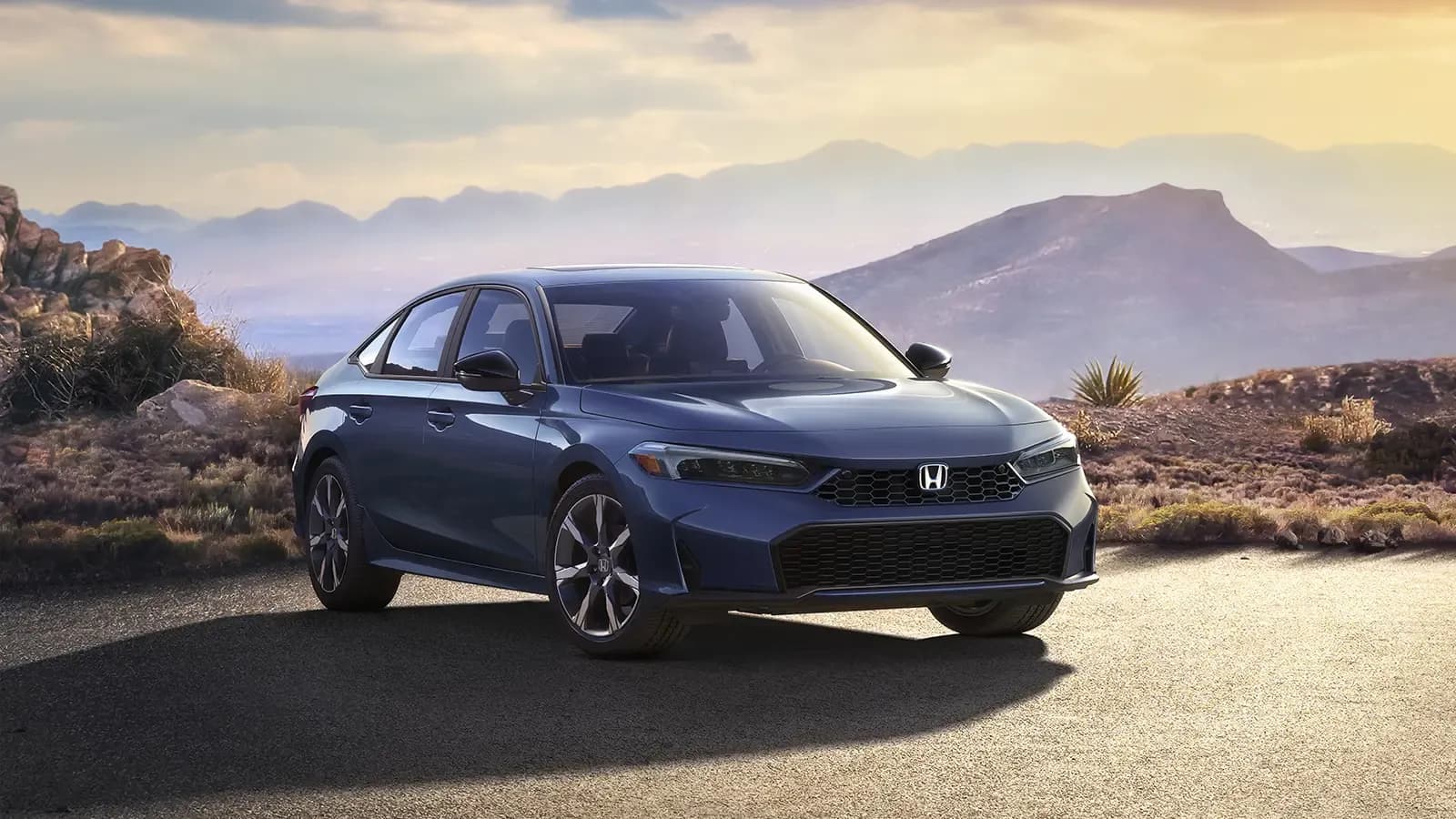 Front three-quarter view of a blue Honda Civic parked on a mountain road.