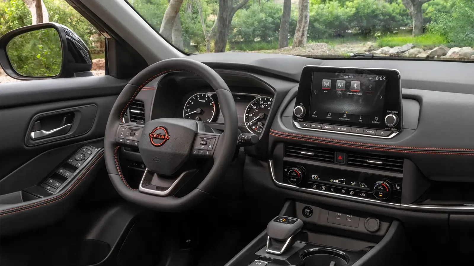 Driver side interior of a 2025 Nissan Rogue in a forest