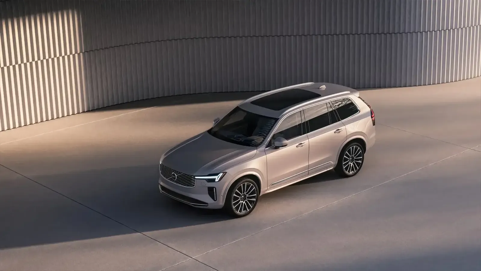 A 2025 Volvo XC90 Mild Hybrid parked near a concrete wall