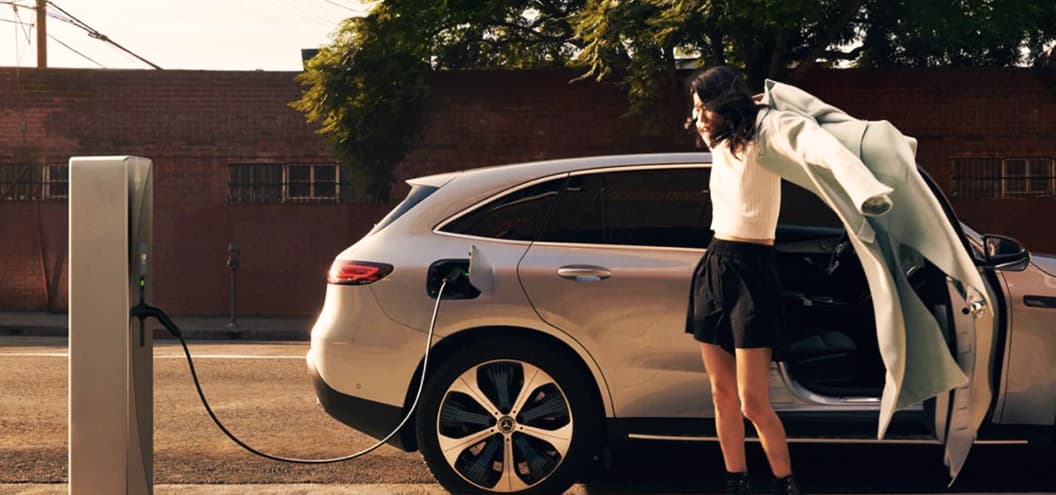 Women getting out of Mercedes Benz EQA that is charging