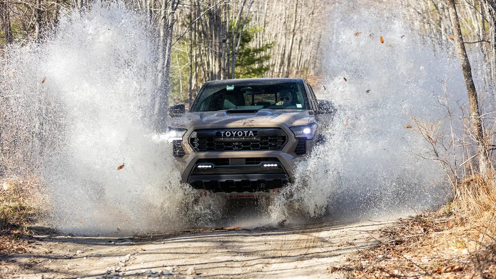 2025 Toyota Tacoma TRD Pro Hybrid off-roading with an epic water splash