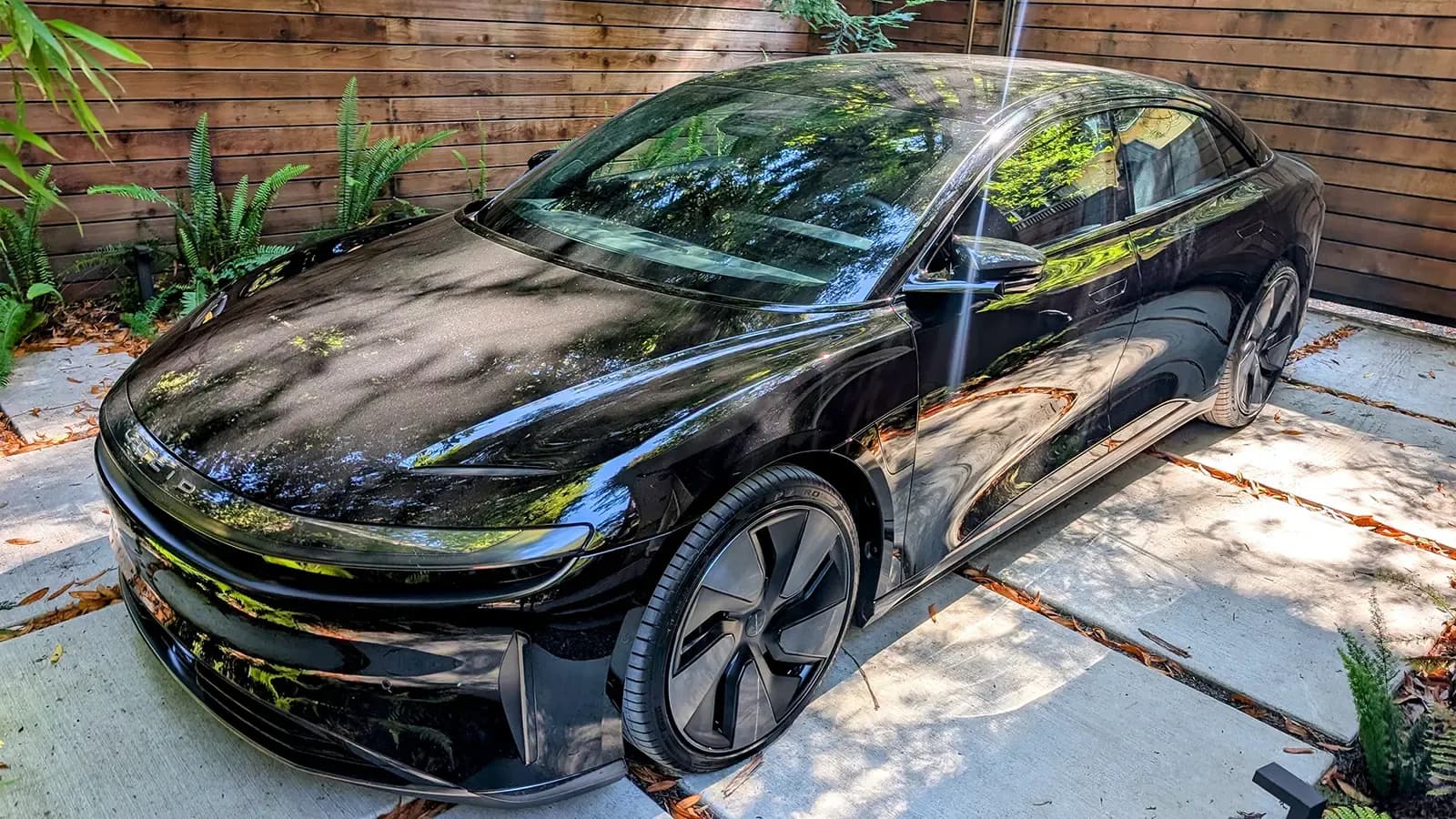A Black 2025 Lucid Air Grand Touring in a beautiful scenic residence background
