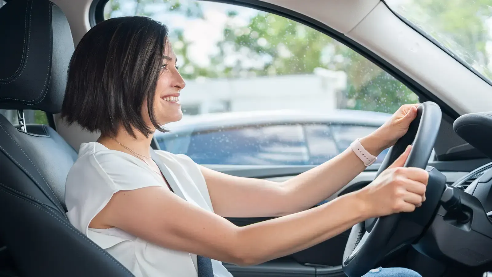 Woman Holding Steering Wheel In New Electric Vehicle