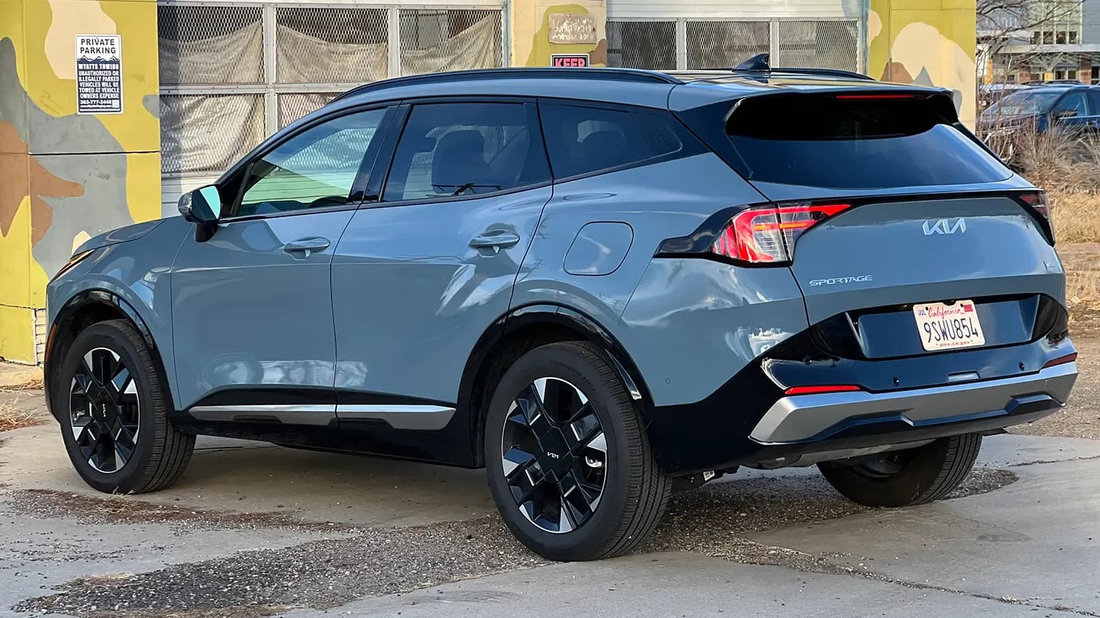 A dark blue 2026 Kia Sportage Hybrid SX Prestige rear three quarter view