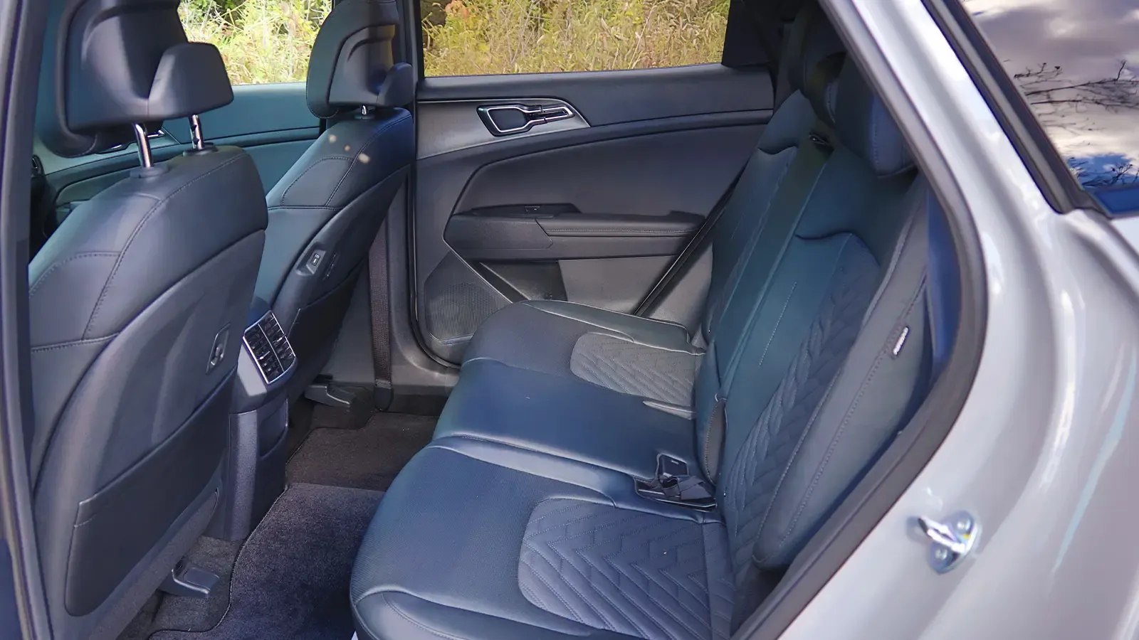 A dark blue 2026 Kia Sportage Hybrid SX Prestige back row view