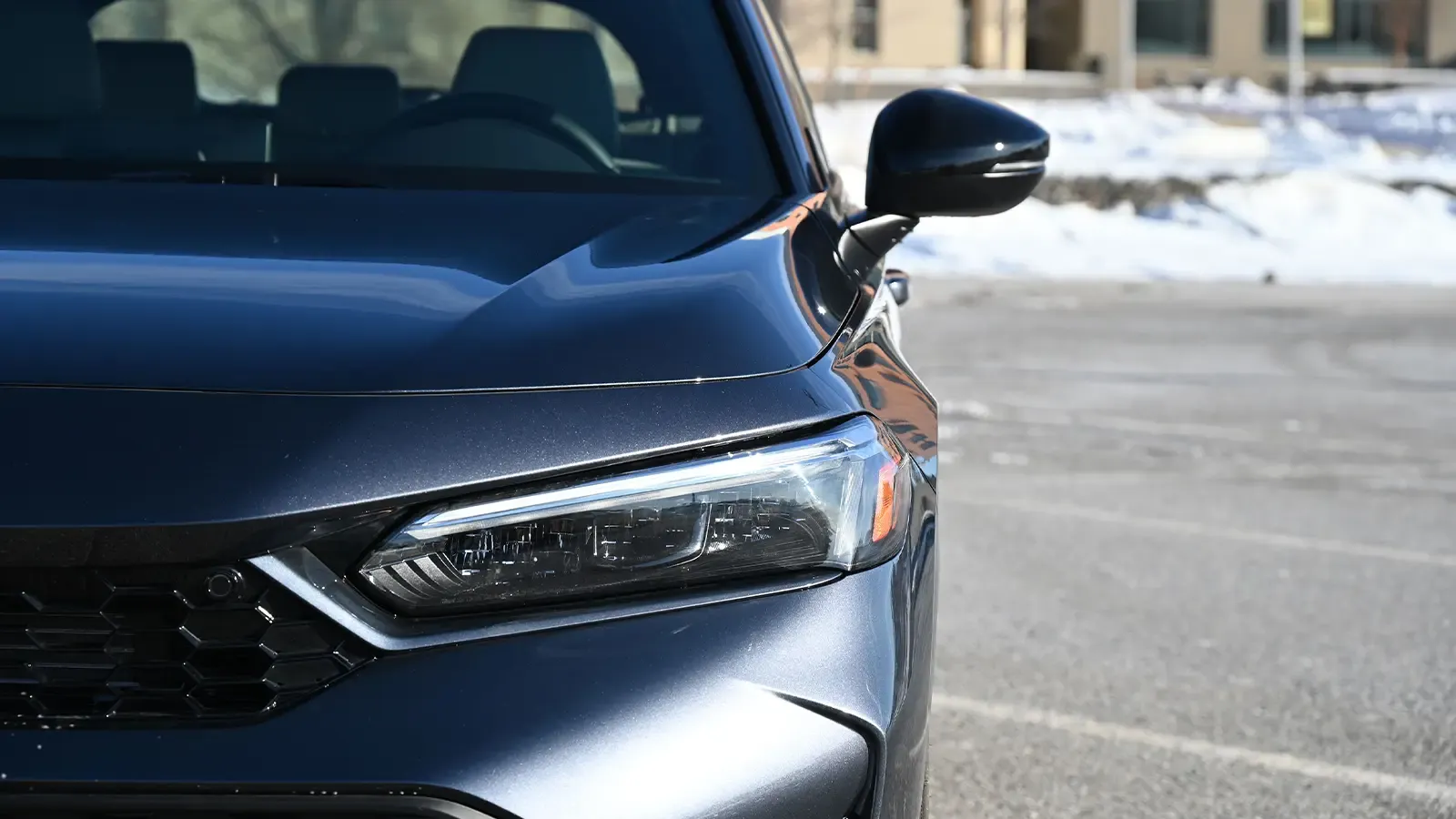 A dark blue 2026 Honda Civic Sport Touring Hybrid nose close up