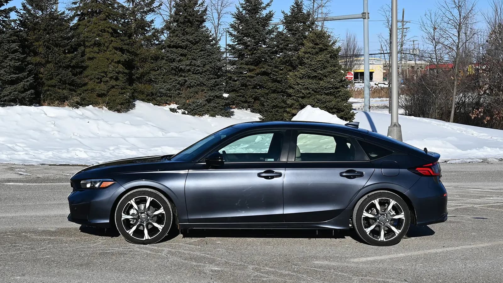 A dark blue 2026 Honda Civic Sport Touring Hybrid side view