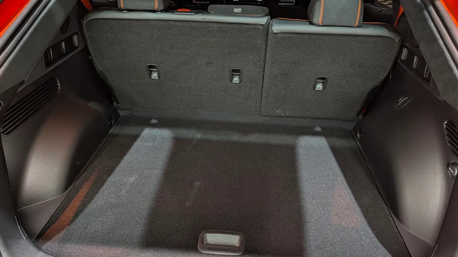 A 2027 Orange Genesis GV60 Magma interior rear cargo bay view lid open