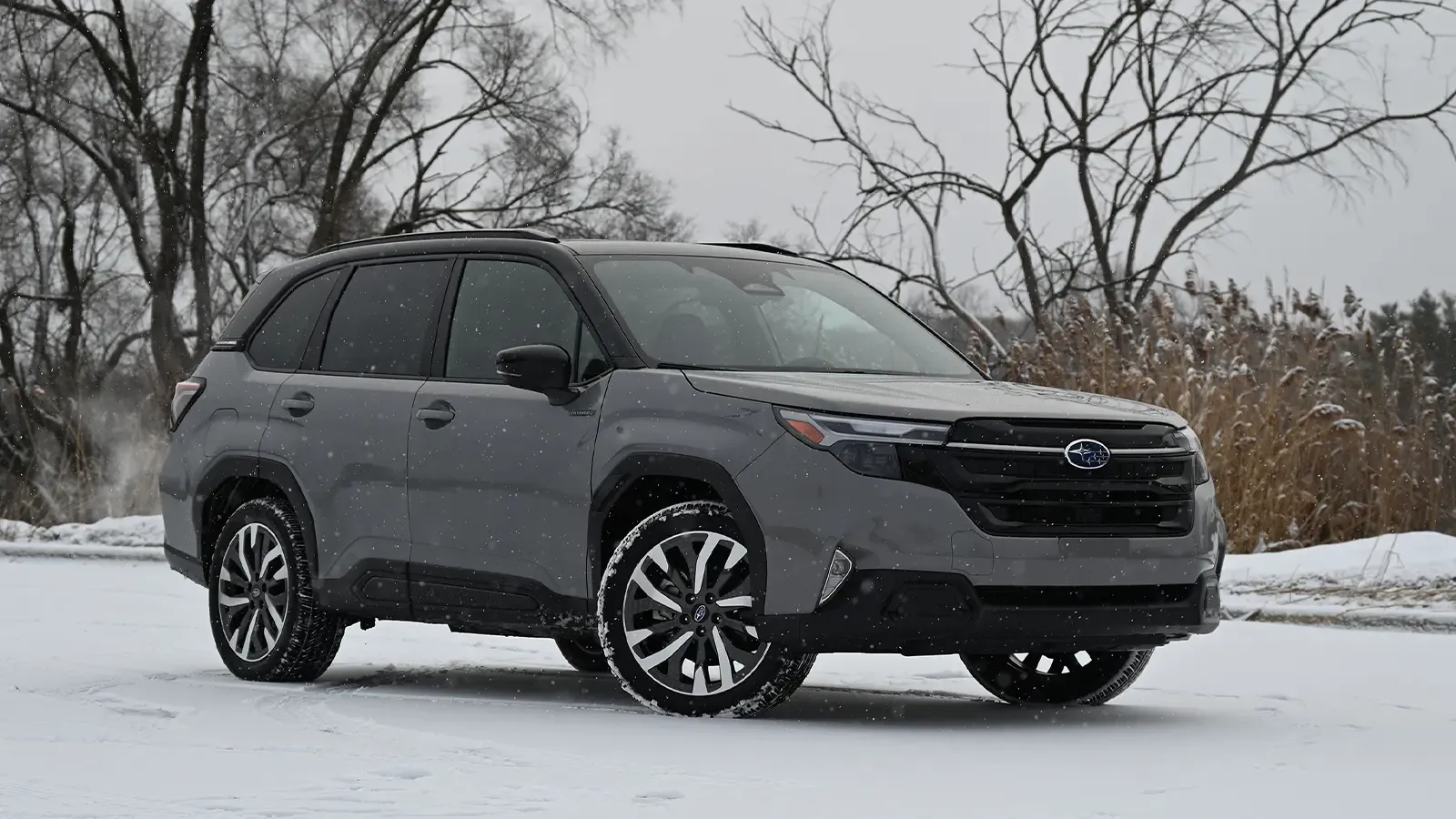 A dark grey 2025 Subaru Forester Touring Hybrid three quarter front view