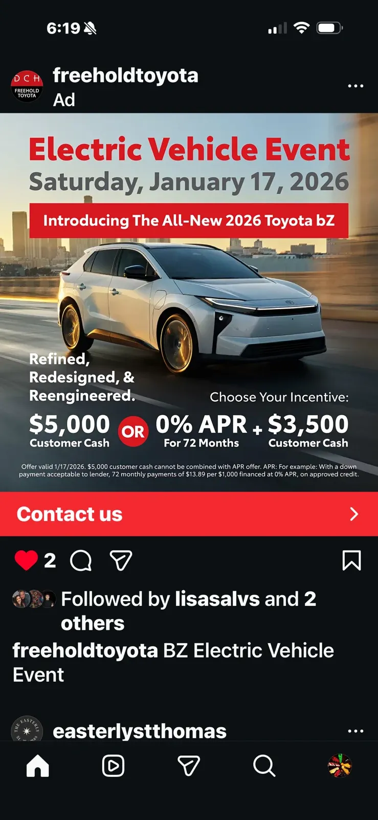 Front three-quarter view of a white Toyota bZ driving on a city road in an event ad.