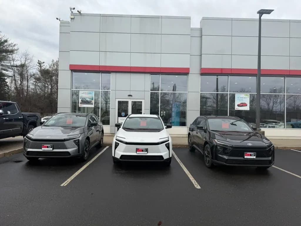 Front view of three Toyota bZ SUVs parked outside a dealership.