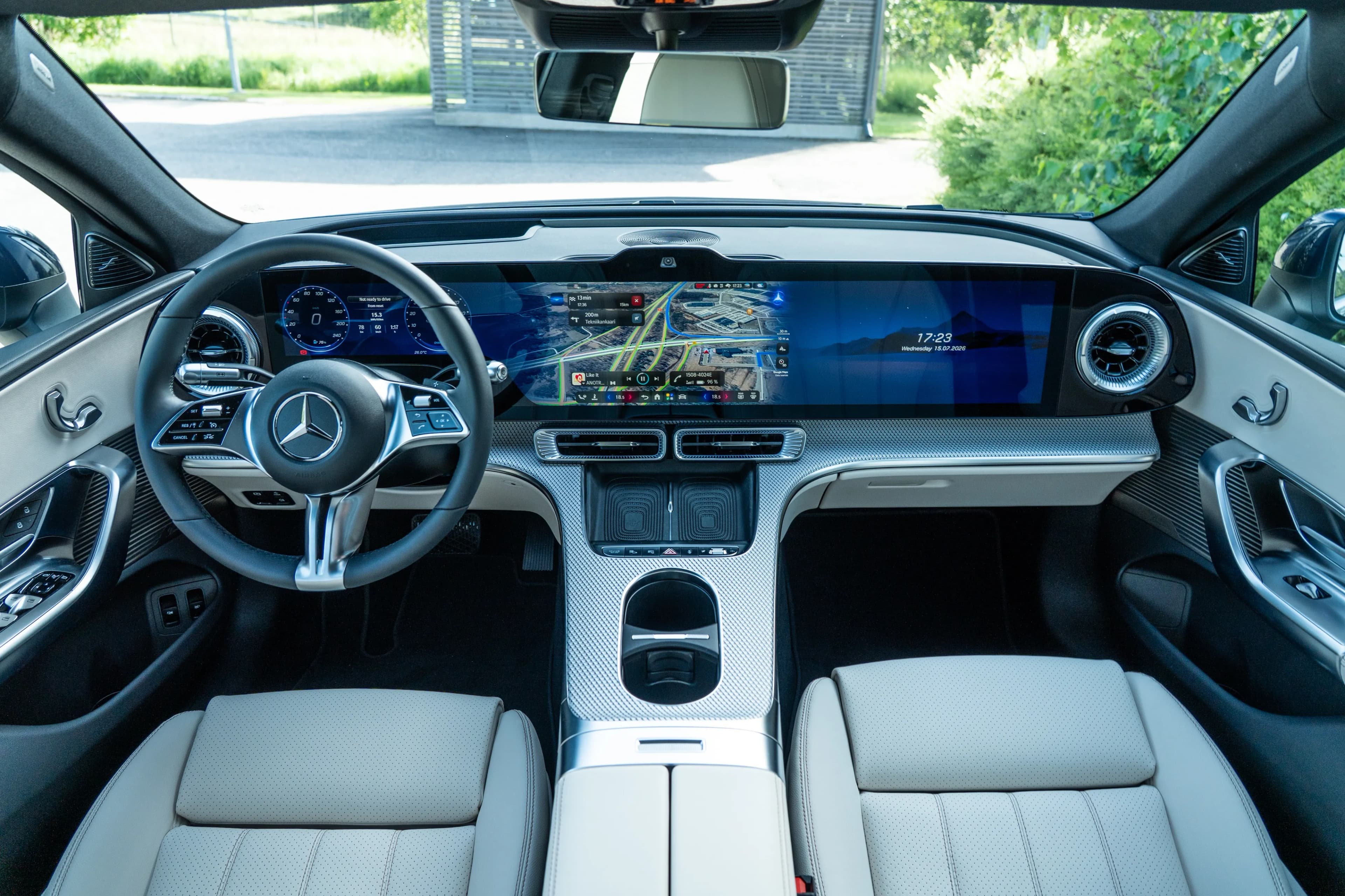 Interior eléctrico del Mercedes-Benz C-Class con pantalla panorámica, volante y navegación visible.