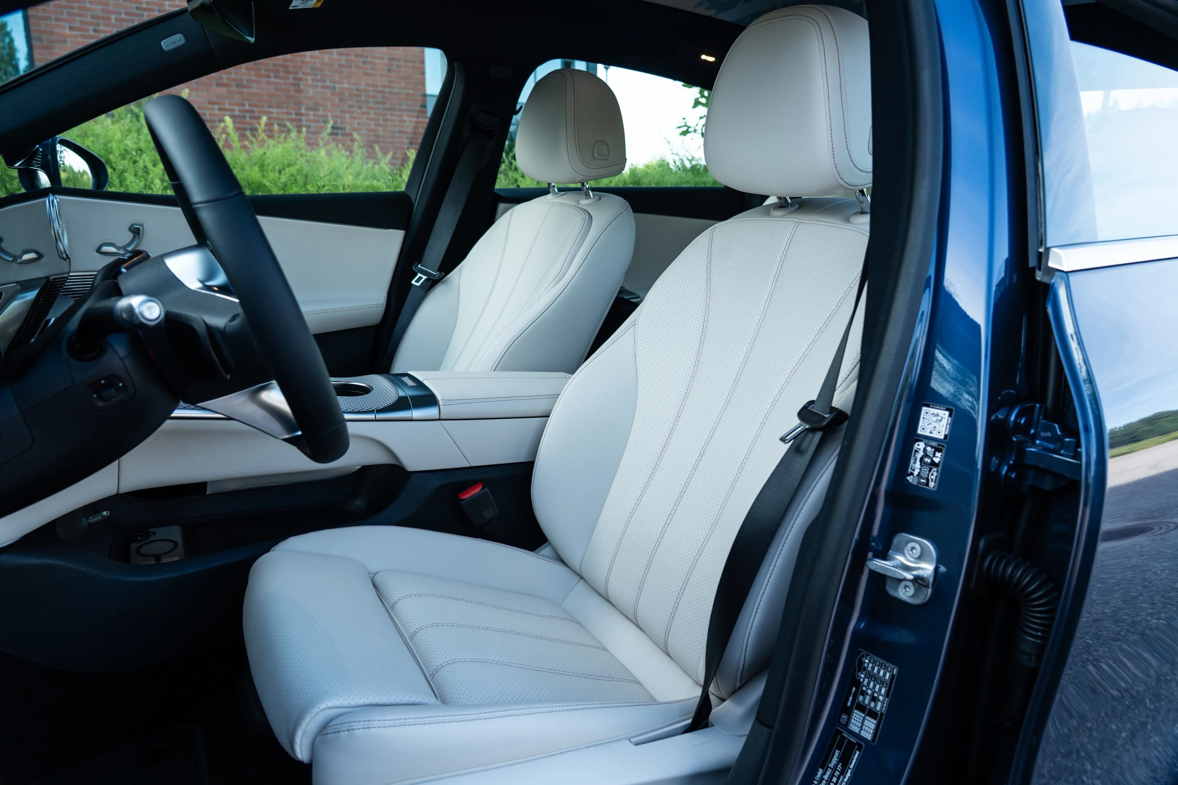 Asientos delanteros y consola central dentro de un Mercedes-Benz C-Class Electric azul.