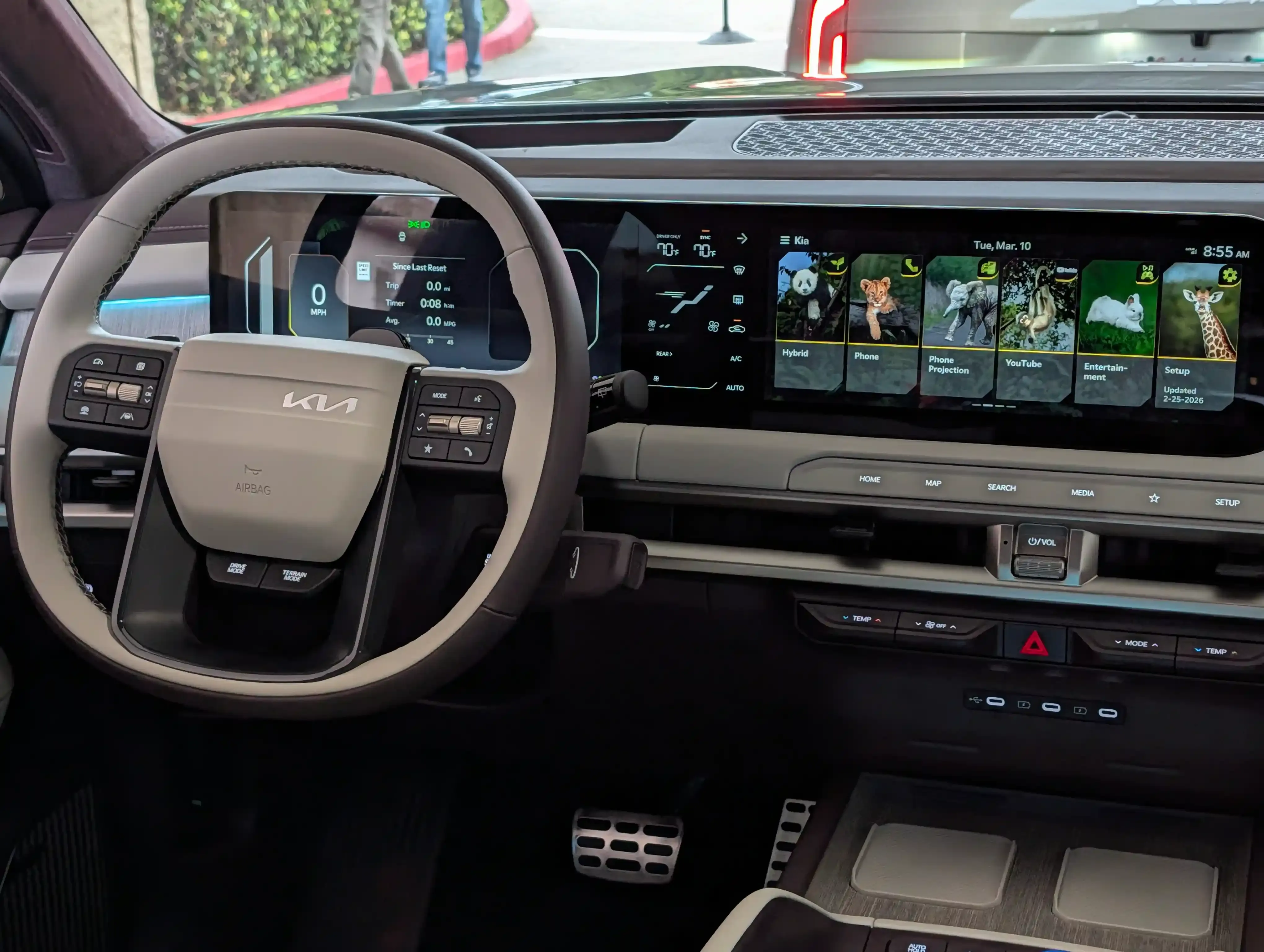 Kia interior with a dual-screen dashboard, steering wheel, and center controls.