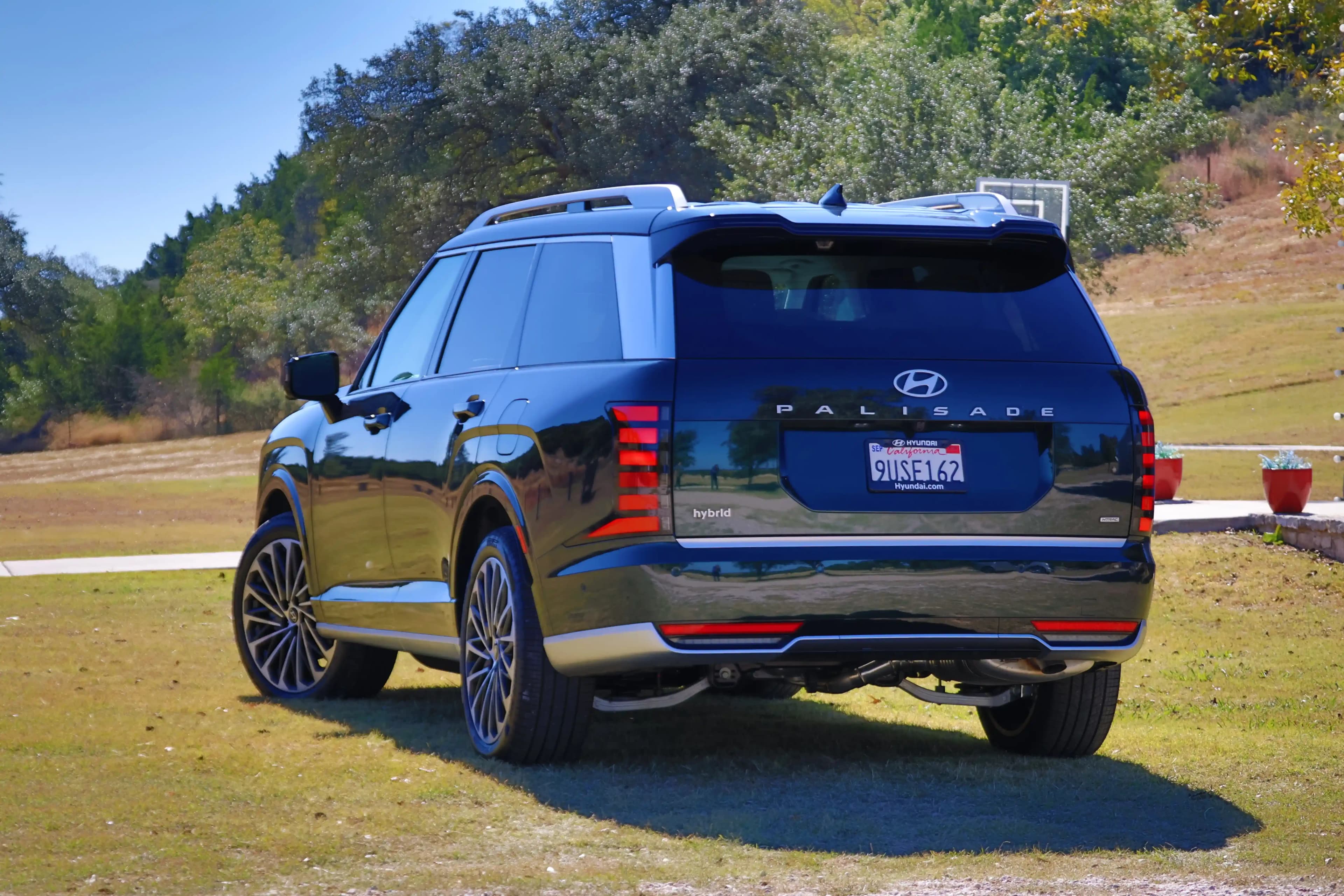 Rear three-quarter view of a Hyundai Palisade Hybrid parked on grass.