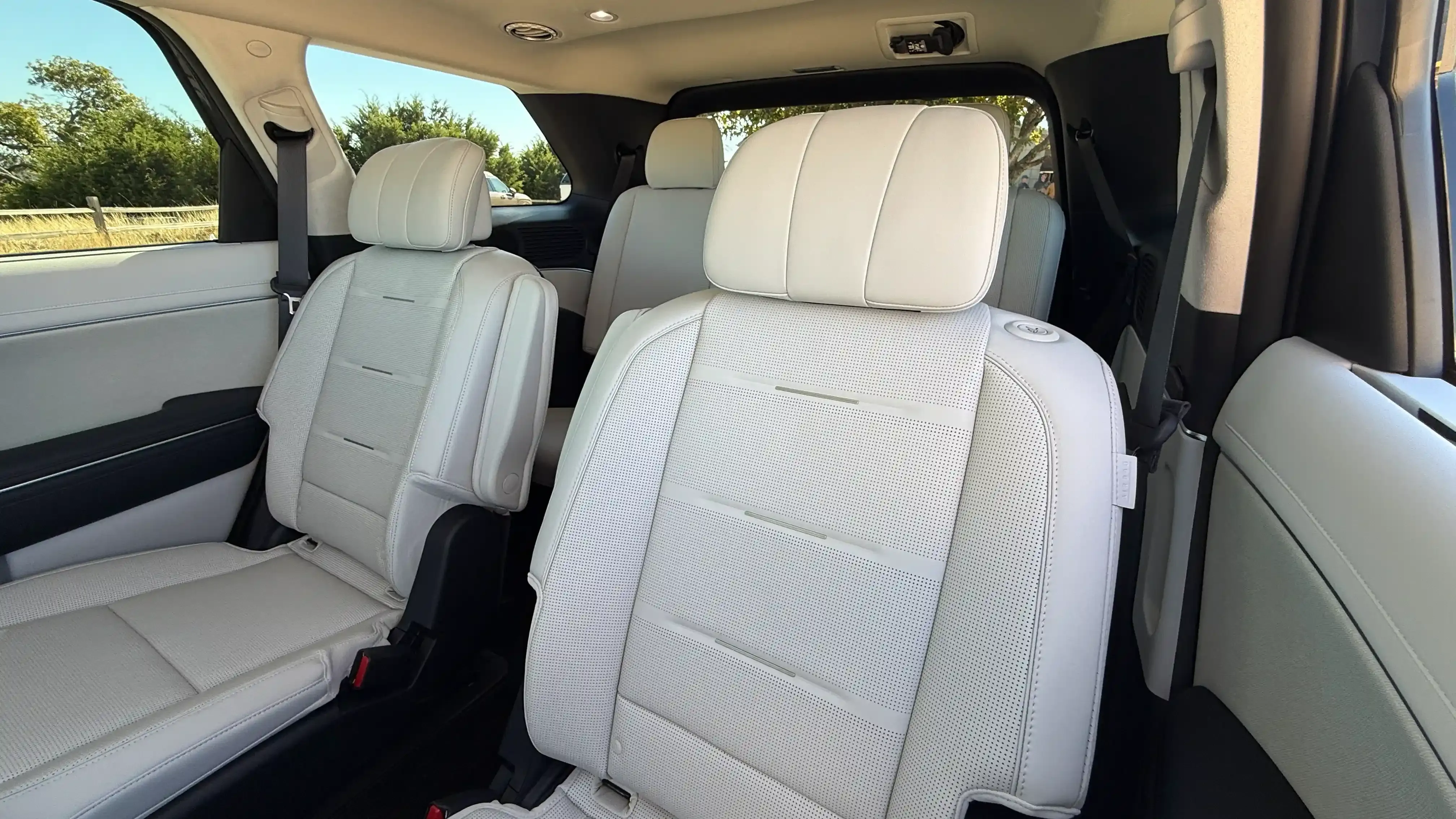 Second-row and third-row seats in a light-colored SUV interior.